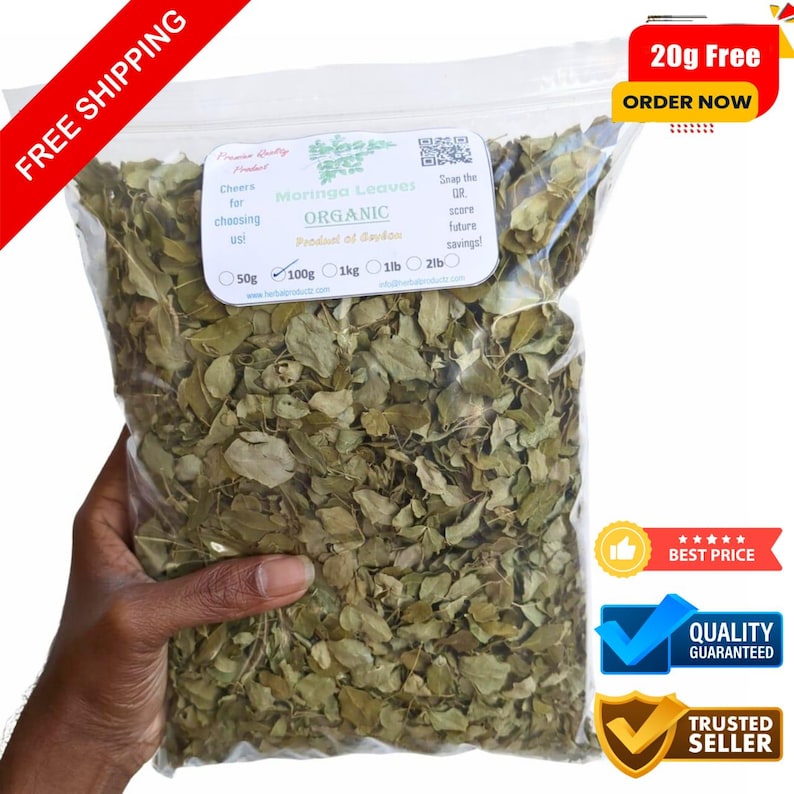 May include: A clear plastic bag filled with dried moringa leaves. The bag has a label that reads "Moringa Leaves ORGANIC" and includes weight options. Additional text includes "Free Shipping" and "20g Free Order Now".