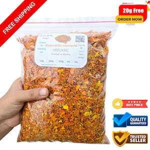 Op de afbeelding: Een doorzichtige plastic zak gevuld met gedroogde oranje en gele calendula-ringelbloemblaadjes. De zak is gelabeld met "Calendula marigold Organic Product of Baydon".