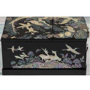 A black lacquer jewelry box with mother-of-pearl inlay depicting cranes and deer amidst floral motifs, showcasing exquisite detailing and traditional design.