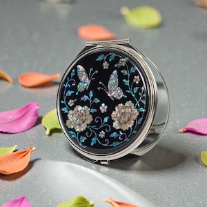 MONTAGNE DE FÉVRIER Miroir compact en nacre avec papillon et motif floral sur fond noir, élégant miroir de poche rond