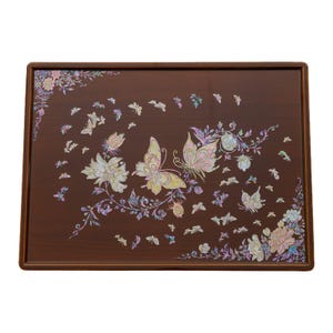 A brown lacquered table with intricate mother-of-pearl inlay of butterflies and flowers on the surface