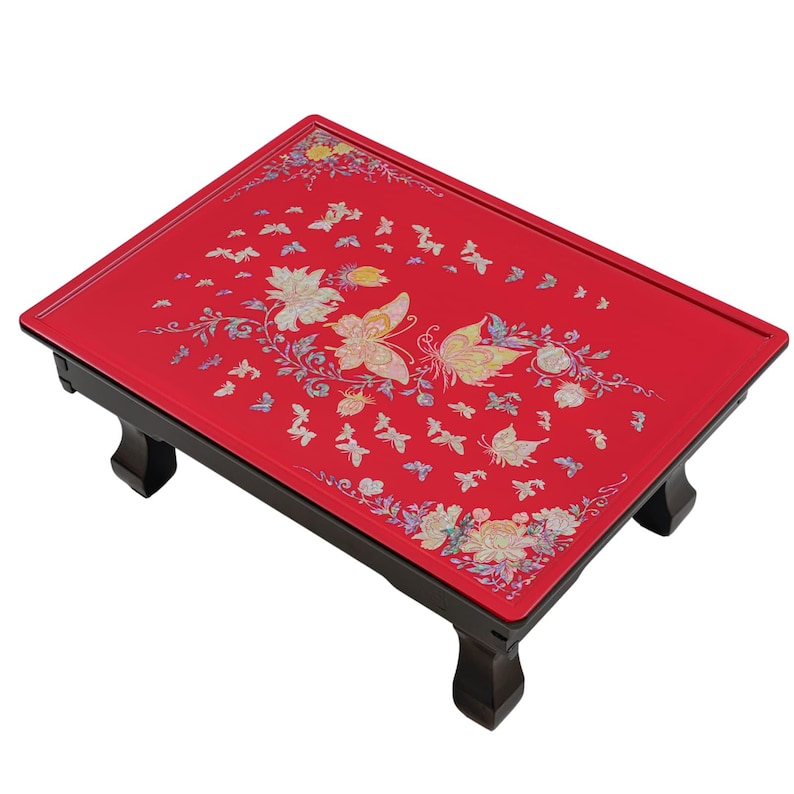 Red lacquered tray with intricate butterfly and floral designs, featuring black foldable legs.