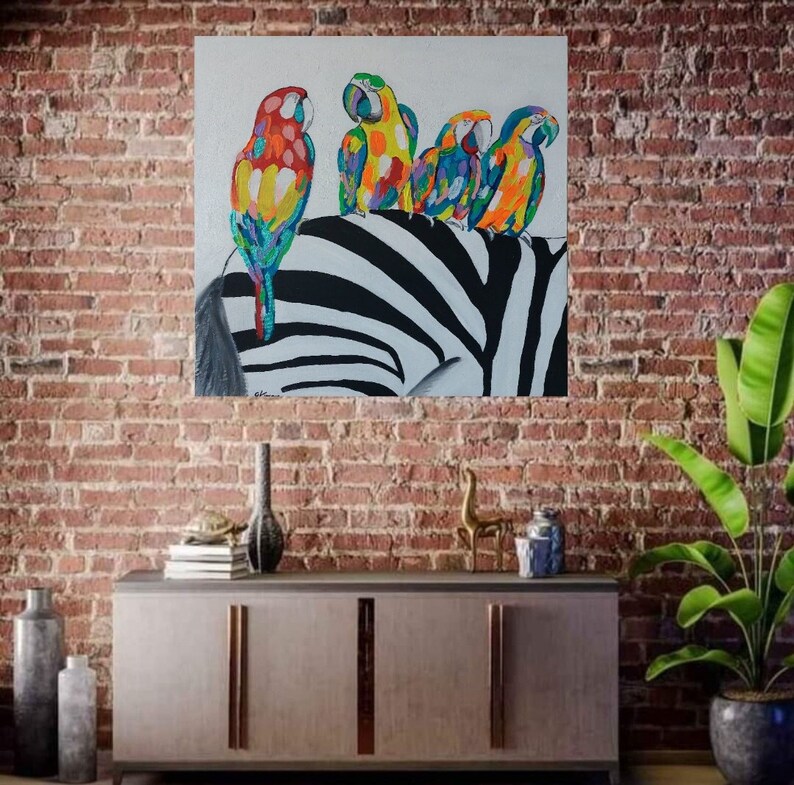 May include: A painting of four colorful parrots perched on a zebra's back. The parrots are a mix of red, yellow, blue, and green. The zebra's stripes are black and white.