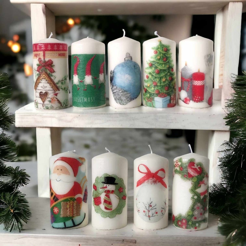 May include: A set of ten white pillar candles with various Christmas-themed designs. The designs include a snowman, a Christmas tree, Santa Claus, and a birdhouse.