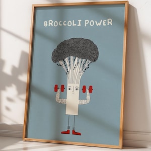 Könnte beinhalten: Ein gerahmter Kunstdruck mit einem Cartoon-Brokkoli-Charakter, der Hanteln hebt. Der Brokkoli hat einen schwarzen, strukturierten Kopf, einen weißen Stiel und rote Schuhe. Die Worte "BROCCOLI POWER" sind oben auf hellblauem Hintergrund gedruckt.