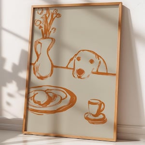May include: A framed wall art print featuring a light beige background with a burnt orange line drawing. The illustration depicts a vase with flowers, a dog peeking over a table edge, a plate with food, and a small cup on a saucer.