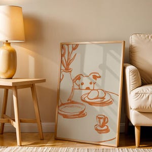 Minimalist terracotta line art poster featuring a curious dog peeking over a kitchen table. The still life scene includes a vase with flowers, plates, and a small coffee cup on a beige background. This modern hand-drawn illustration captures a cozy home or cafe vibe. Perfect as a gift for dog lovers, this aesthetic pet-themed wall decor fits boho and neutral interiors. High-quality physical print for kitchen, dining room, or living room wall art.