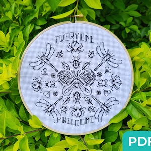 May include: Black and white embroidery hoop featuring the words "Everyone Welcome" surrounded by a design of butterflies, dragonflies, and other insects.
