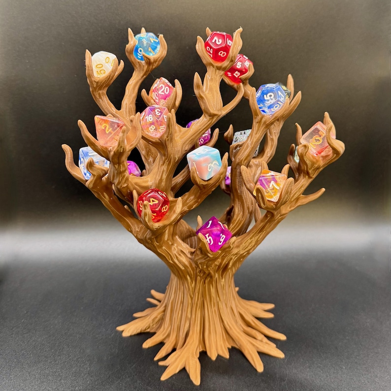 Peut inclure: Un pr&eacute;sentoir en forme d'arbre marron pour d&eacute;s, avec plusieurs branches tenant chacune un d&eacute; multicolore. Les d&eacute;s sont de diff&eacute;rentes couleurs, dont le rouge, le bleu et le violet. Con&ccedil;u pour exposer et ranger les d&eacute;s.
