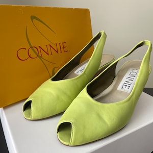 May include: A pair of lime green peep-toe slingback heels with the brand name "Connie" on the inside of each shoe.