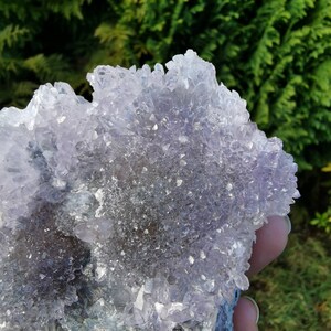 May include: A cluster of amethyst crystals with a purple and white color. The crystals are arranged in a cluster and have a rough, natural texture.