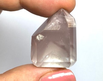 May include: A clear, faceted, purple crystal point with white inclusions. The crystal is approximately 2 inches tall.