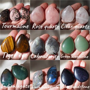 K&ouml;nnte beinhalten: Sortiment von 10 Paaren tropfenf&ouml;rmiger Edelstein-Anh&auml;nger. Die Steine umfassen Turmalin, Rosenquarz, klarer Quarz, Tigerauge, Labradorit, gr&uuml;ner Aventurin, indischer Achat, Flash-Labradorit und blauer Sandstein.