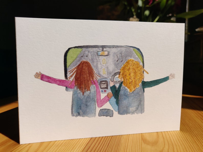 May include: Watercolor painting of two people in a car with their arms out the windows. The car is driving down a road with music notes in the air. The people have brown and blonde hair.
