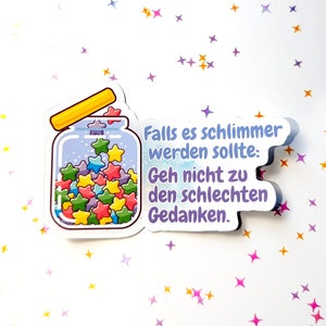Op de afbeelding: Een sticker met een pot vol kleurrijke sterren en de tekst "Falls es schlimmer werden sollte: Geh nicht zu den schlechten Gedanken."