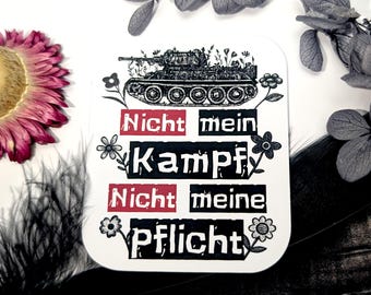 May include: A white sticker with a black and white illustration of a tank with flowers growing on it. The sticker has the text "Nicht mein Kampf Nicht meine Pflicht" in black and red.
