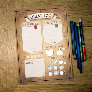 Op de afbeelding: Een afdrukbare quest log tracker met secties voor hoofdquests, side quests, notities, stemming, stress en aanvullen. De tracker heeft een middeleeuws thema met een bruine achtergrond en decoratieve randen.