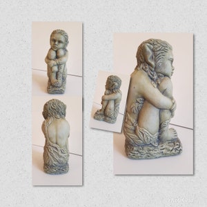 May include: Three gray stone garden statues of mythical creatures with leafy details. The statues are sitting with their legs crossed and their arms wrapped around their bodies.