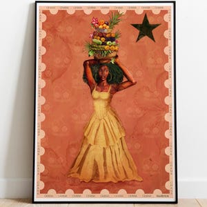 May include: A framed art print featuring a woman in a yellow dress carrying a basket of fruit on her head. The artwork has a warm color palette with a star and the word "Ghana" repeated around the border. The woman has green hair.
