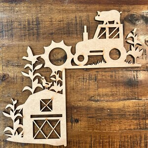 May include: Wooden cutout of a farm scene with a tractor, barn, sun, corn, and a pig. The tractor has a pig on top of it.