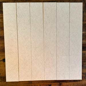 May include: A set of six unfinished wood planks, each with a smooth, light brown surface. The planks are arranged in a vertical row, creating a rustic and natural look.