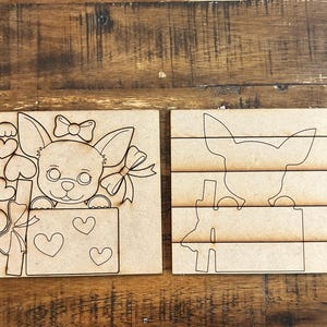 以下が含まれることがあります： 2つの木製チワワをテーマにしたパズル。1つのパズルは、リボン、ハート、ギフトが付いたチワワが特徴です。もう1つのパズルは、チワワの分解されたアウトラインです。どちらのパズルも明るい茶色の木材で作られています。