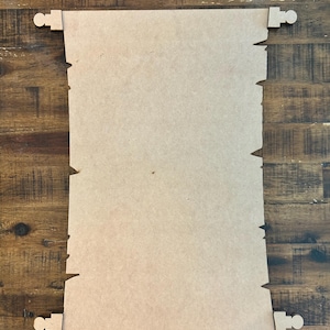 May include: A blank, unfinished wooden scroll with a distressed edge and four wooden scroll holders. The scroll is made of light brown wood and is ready to be painted or stained.