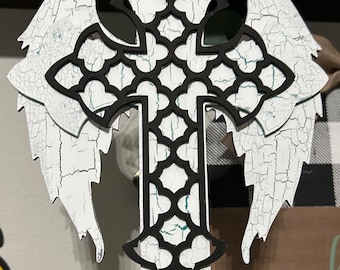 May include: White wooden cross with black cutout design and distressed white paint finish. The cross has wings on either side.