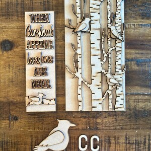 May include: Wooden craft kit with a sign that reads "When Cardinals Appear Loved Ones Are Near". The kit also includes a birch tree background, a cardinal bird, and the letters "CC".