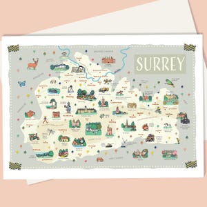 May include: A decorative map of Surrey, England, featuring illustrated landmarks and icons. The map is in a light gray color with green, blue, and brown accents. The word "SURREY" is printed in a light green color. The map is on a white background.