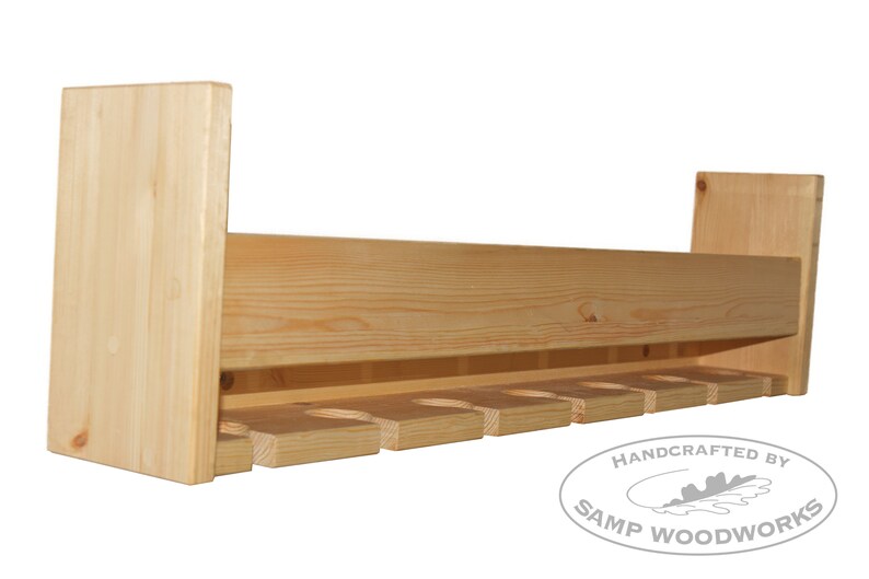 May include: A wooden wine rack with a natural finish and eight slots for holding wine bottles. The rack is handcrafted by Samp Woodworks.