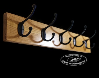 May include: A wooden coat rack with six black metal hooks. The rack is handcrafted by Samp Woodworks.