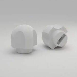 May include: Two white, plastic knobs with a rounded top and a flat base. One knob has a slot for a screwdriver. The knobs are likely used for furniture or other household items.
