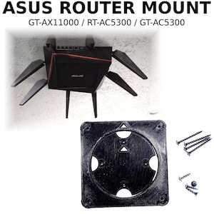 May include: Black ASUS router mount with the text "ASUS ROUTER MOUNT" and model numbers. The mount includes a black router with multiple antennas and a black mounting plate with screws.