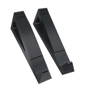 May include: Two black, angled laptop stands. Each stand has a triangular shape with a cutout and a small ledge at the bottom. The stands are made of a solid material and are designed to elevate a laptop.