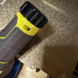 May include: A handheld power tool with a black and yellow design. The tool has a textured gray grip and a black top. The yellow accents create a striking contrast against the darker colors. The tool is likely used for various DIY projects.