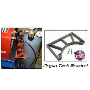 Puede incluir: Soporte negro para tanque de argón con diseño curvo. La imagen también muestra una máquina de soldar y un tanque de argón con un regulador. El soporte está 'Made in USA'.