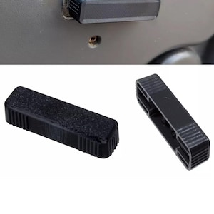 May include: Black rectangular plastic part with a textured surface, possibly a car door handle component. The part is shown in different views, including one installed and two separate pieces.