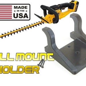 May include: A yellow and black hedge trimmer with a wall mount holder. The holder is gray and includes screws for installation. The image also features a "Made in the USA" label with the American flag and the words "WALL MOUNT HOLDER".