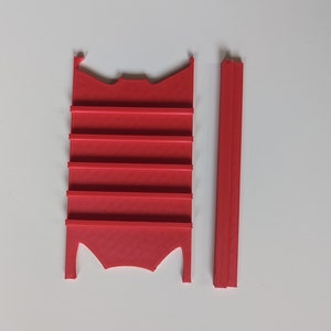 May include: Red plastic 3D printed shelf unit with six shelves and a separate red plastic support piece.