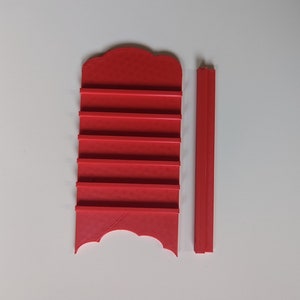 May include: Red plastic shelf with six slots and a separate red plastic support pole.