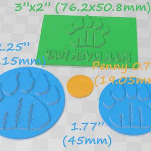 May include: Three blue silicone molds with a paw print design and three pine trees inside the print. The molds are 2.25 inches, 1.77 inches, and 0.75 inches in diameter. A green silicone mold with the same design is 3 inches by 2 inches. A penny is included for size comparison.