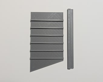 May include: A grey 3D printed wall shelf with seven shelves and a separate grey 3D printed vertical piece.