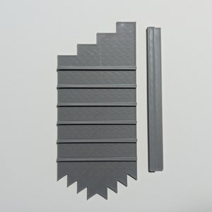 May include: A gray plastic shelf unit with seven shelves and a pointed bottom. The unit is made up of two pieces, a main shelf unit and a side piece.