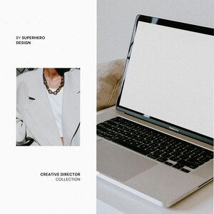 May include: A silver laptop with a blank white screen and black keyboard next to an inset image of a light gray blazer worn with a white top and a thick gold chain necklace. The text reads BY SUPERHERO DESIGN and CREATIVE DIRECTOR COLLECTION.