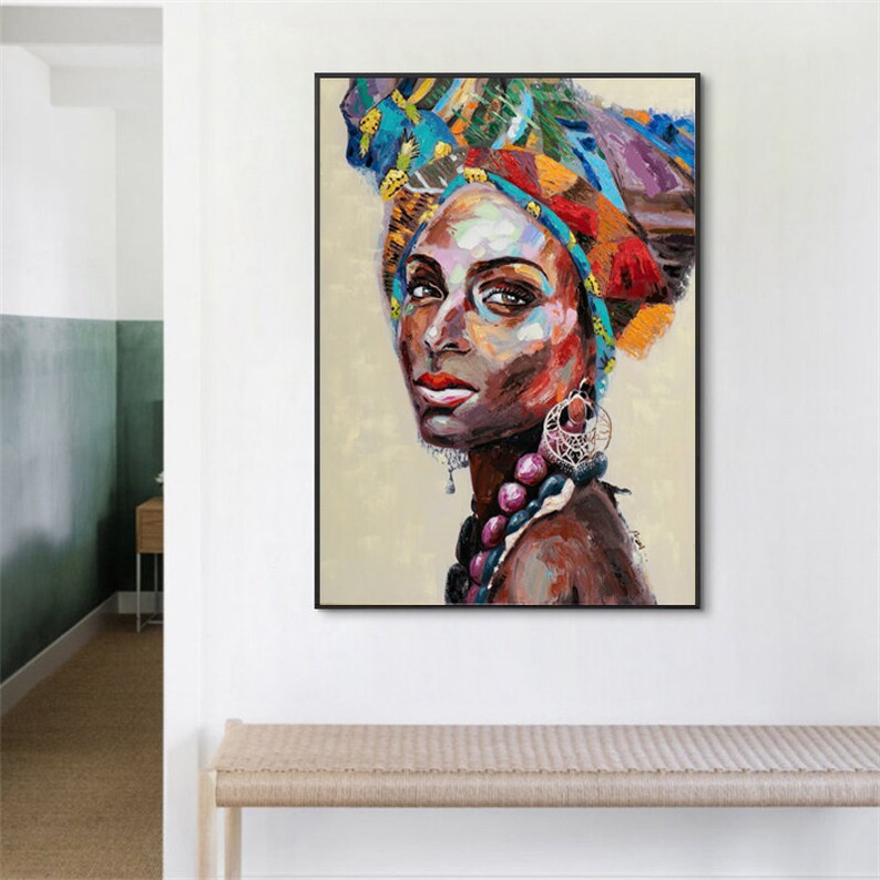 May include: A colorful painting of a woman with a patterned head wrap and beaded necklace. The woman's face is painted in a realistic style with a focus on her eyes and lips.