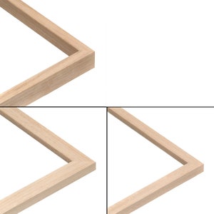 May include: A close-up of a light-coloured wooden picture frame. The frame is rectangular with a simple, clean design. The wood grain is visible, and the corners are precisely joined. The background is plain white.