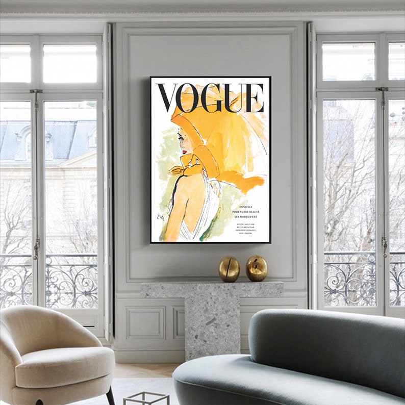 May include: A vintage Vogue magazine cover featuring a woman wearing a yellow headscarf and a white dress. The cover text reads "VOGUE" in black letters.