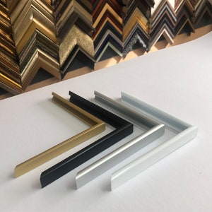 May include: Four picture frame moulding samples in gold, black, silver, and white. The moulding is made of metal and has a simple, modern design.