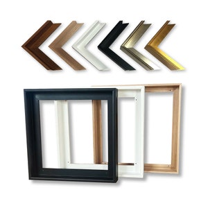 May include: Three different wood canvas stretcher bars in black, white, and natural wood. The bars are stacked on top of each other. The top of the bars are visible in the image. The bars are used to create a canvas frame for painting.